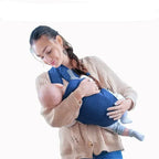 Woman holding a baby in a blue baby carrier 