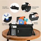 Black stroller bag on a wood table with various compartments and features highlighted on a beige background