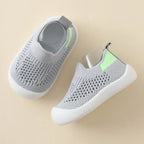 Gray slip-on shoes with green accents on a beige background