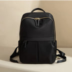 Black backpack with gold zipper on a beige background