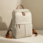 Ivory backpack with brown straps and accents on a beige background