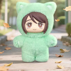Green plush toy in a cat costume with a blurred outdoor background