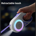 Illuminated purple retractable leash device with hand holding it against a dark background