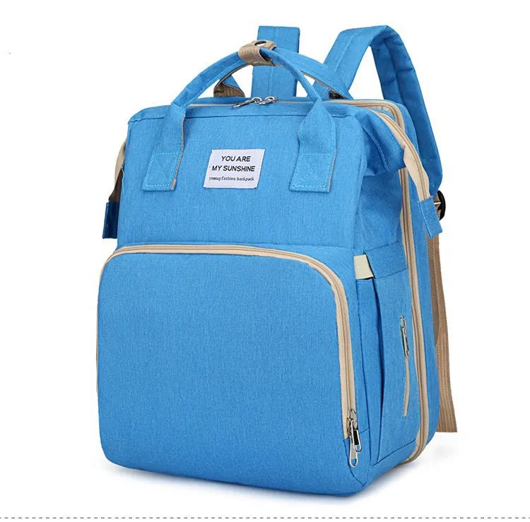 Light blue multifunction portable diaper backpack with white accents on a white background