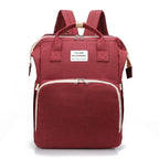 Red multifunction portable diaper backpack with white accents on a white background