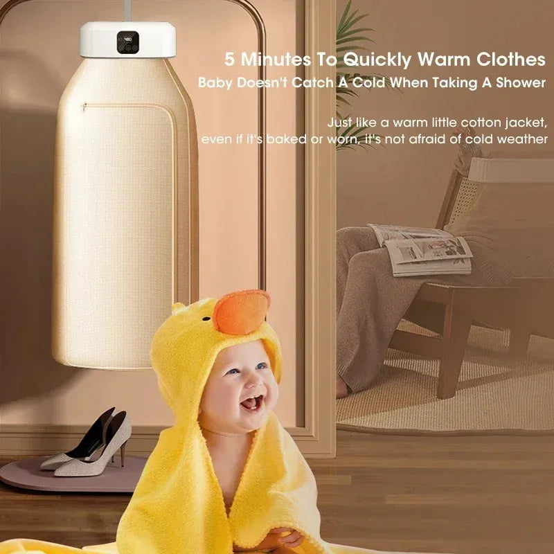 Baby wrapped in a yellow towel with duck design, sitting by a  hanging portable dryer