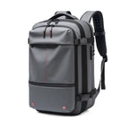 Gray vacuum compression backpack with red accents on a white background